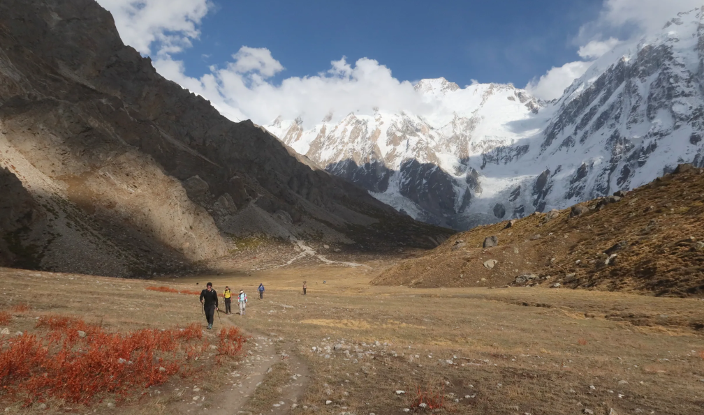 Neyret - Pierre - Randonneurs marchant dans une vallée de pelouses séchées, vue sur le Nanga Parbat, Pakistan - Trek autour du Nanga Parbat avec Pierre Neyret  - 6
