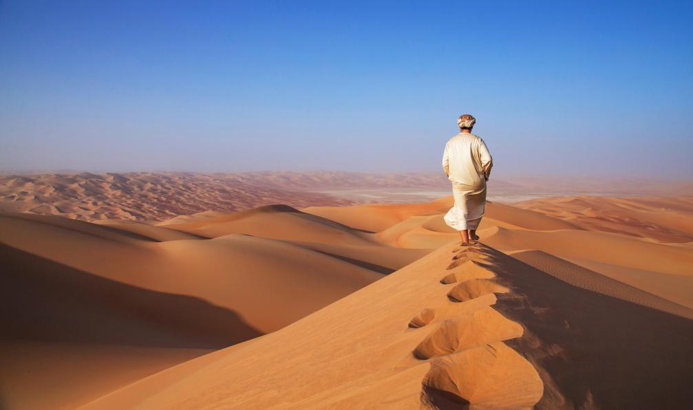 Katiekk2 -  Istock -  Homme marchant dans le désert, Oman.  - Le Rub Al Khali et ses dunes infinies - 6