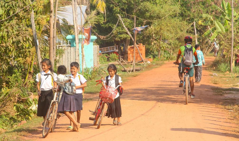 vélorizon - Cycliste croissant des enfants en vélo sur une route en terre, circuit Le meilleur du Cambodge a vélo, Cambodge - À vélo au coeur du Cambodge - 5