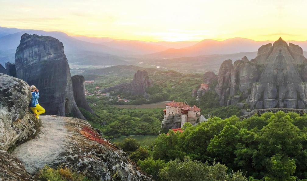 Silalena - stock.adobe.com - Randonneuse admirant l'un des six monsatères des Métérores et la vallée au coucher du soleil, Grèce - Sentiers mythiques : Métèores, Olympe et Pélion - 1