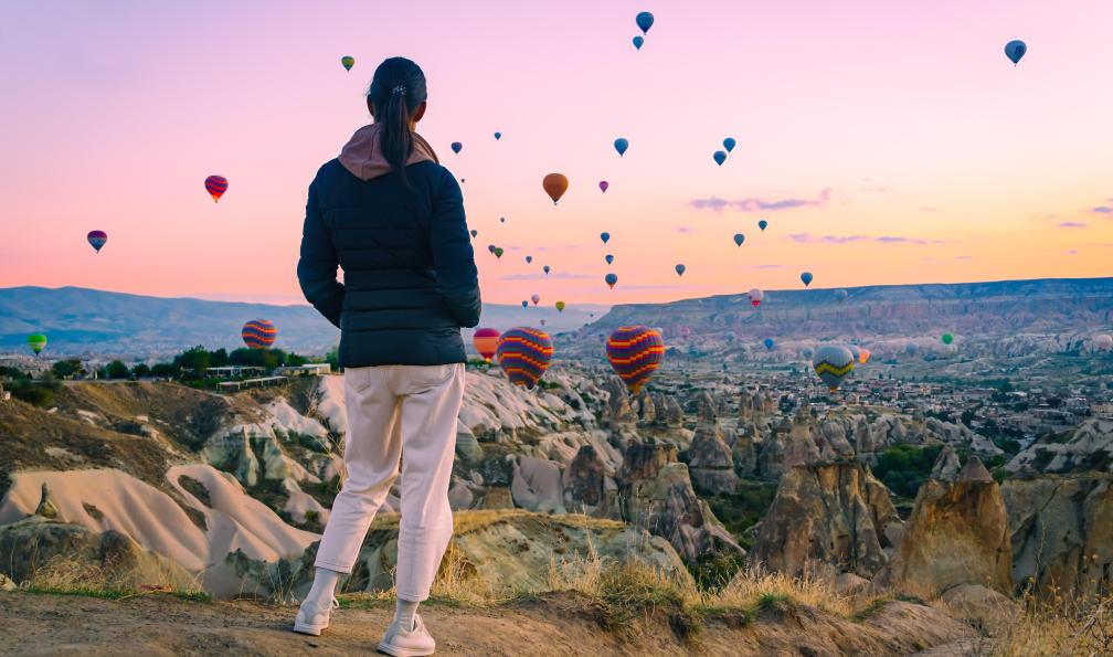 Leonid - Adobe Stock - Jeune femme regardant le lever du soleil et les montgolfières décoller au-dessus de la vallée en Cappadoce, Goreme, Turquie - L'odyssée des petits sultans - 8