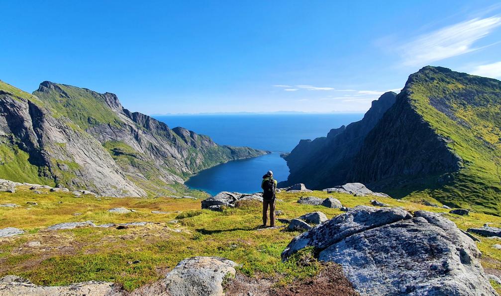 Garioud - Nadège - Randonneur descendant de Munken devant le Djupfjorden et son pont reliant les terres, la mer au loin, Lofoten, Norvège - Archipels du Nord : Lofoten, Vesterålen et Senja - 12