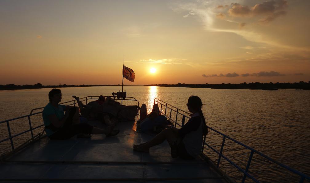 Claire Spaïni -  Personnes sur un bateau, regardant le coucher du soleil, Cambodge.  - Au coeur du Cambodge - 7