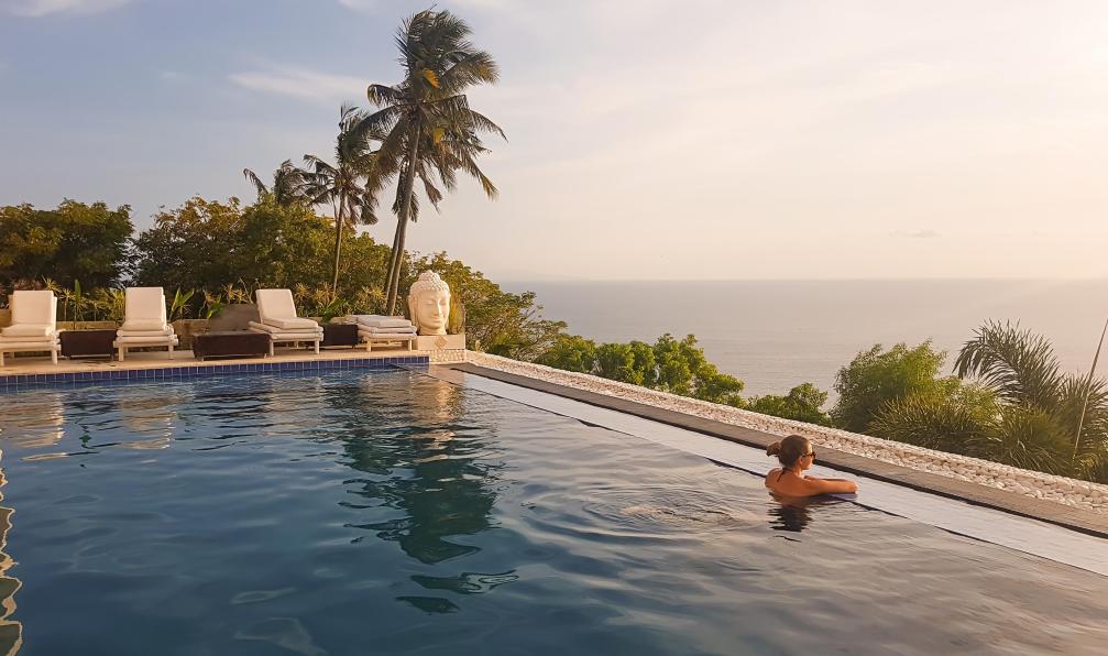 Chris - Adobe Stock - Femme qui se baigne dans une piscine à débordement, regardant le soleil se coucher dans la mer depuis un hôtel à Lombok, Bali, Indonésie - Trois volcans et la mer turquoise - 9