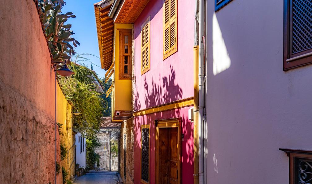 Rakin - Vlad  - Adobe Stock - Une rue étroite pavée descend à travers la vieille ville de Kaleici, bordée dune maison ottomane rose aux volets en bois et dun haut mur orné darbres verts sous un ciel bleu éclatant. Antalya, Turquie. - Friandises de Lycie - 11