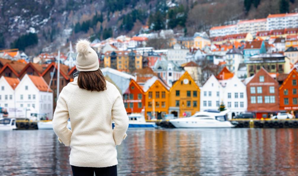 moofushi - Adobe Stock - Femme qui regarde le quartier coloré de Bryggen à Bergen, Norvège. - Découverte hivernale des fjords norvégiens - 1