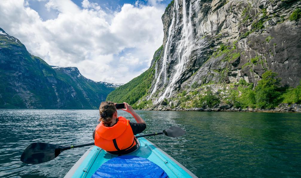 AlexanderNikiforov - Adobe Stock - Kayakiste prenant une photo d'une chute d'eau au Geirangerfjord, Norvège - Randonnées au coeur des fjords - 7