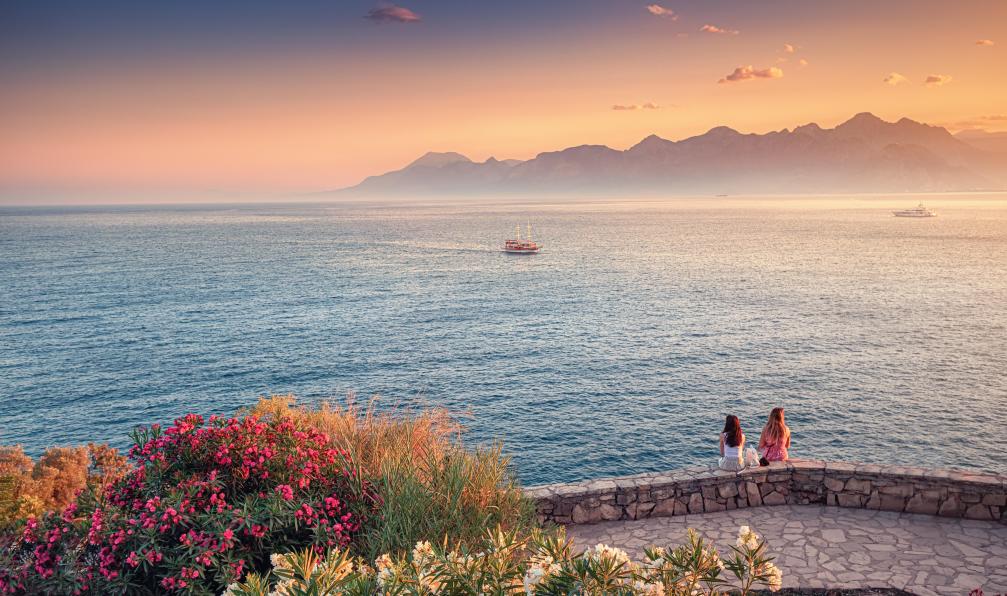 EdNurg - Adobe Stock - Deux amies sont assises pour regarder le coucher de soleil lumineux sur la mer Méditerranée - Sentiers des dieux et criques turquoises - 9
