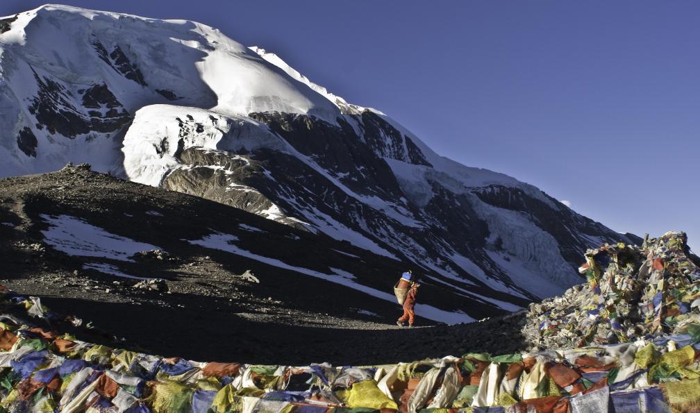 Porteur et drapeaux à prières au Thorung-La, Tour des Annapurnas, Népal. - Le grand tour des Annapurnas - 4