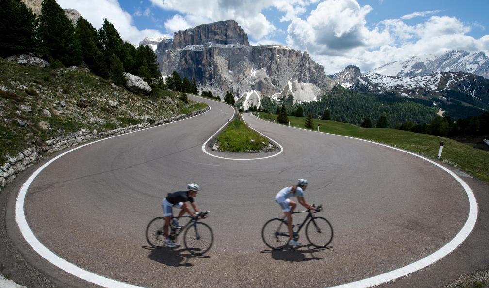 NikonSteff - Adobe Stock - Cycliste en descente dans un virage avec vue sur les Dolomites, Italie - Le grand tour des Dolomites à vélo - 2