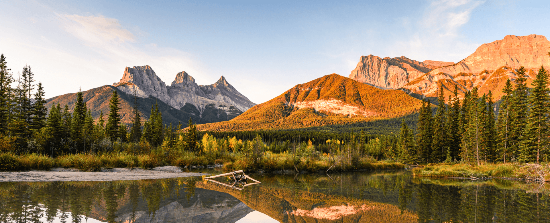 Three Sisters surplombant l’étang au lever du soleil en automne dans le parc national de Banff, Canada