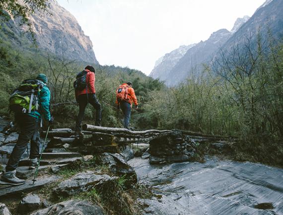 Groupe de marcheurs traversant un pont au dessus d'une rivière.