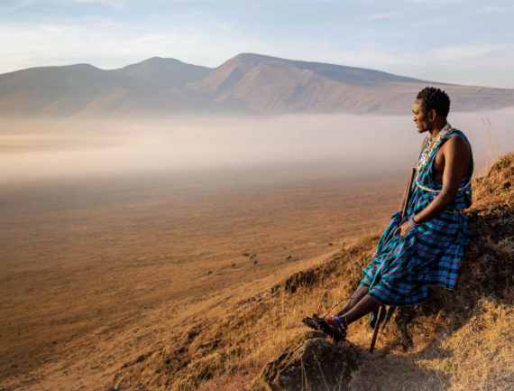 Masai assis au bord d’un des cratères de Ngorongoro, regardant l’horizon, Tanzanie