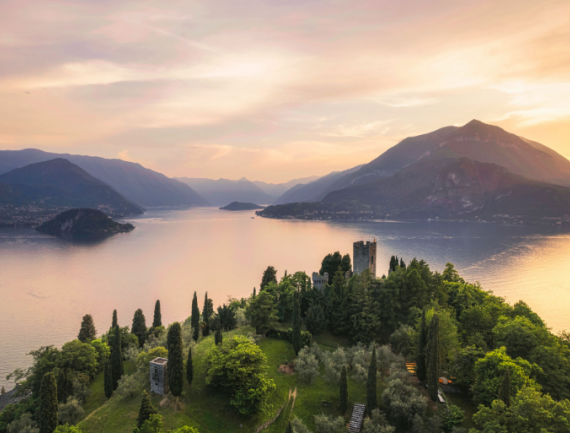 Château de Vezio avec le village de Varenna et les montagnes en arrière-plan au coucher du soleil d’été, lac de Côme, Italie