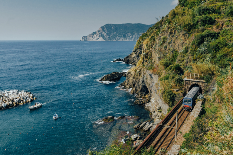 Train sur les rails en approche de Vernazza le long du littoral, Cinque Terre, Italie